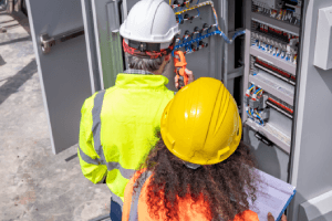 Engineers Inspecting Electrical Panel at Industrial Site