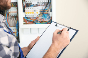 Electrical Inspector Inspecting Wiring with Checklist