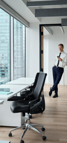 Professional Man Using Phone Leaning in Modern Office
