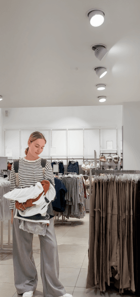 Blonde Woman Shopping for Clothes in Retail Store